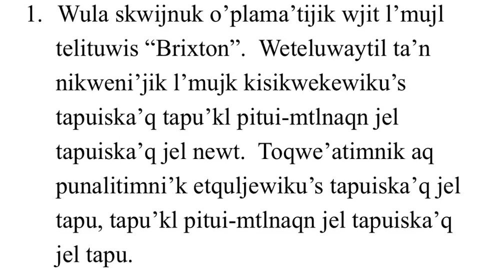 Des phrases en mi'kmaw écrites en noir sur un fond blanc.