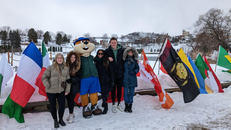 Des gens devant le lac Saint-Louis et des drapeaux.