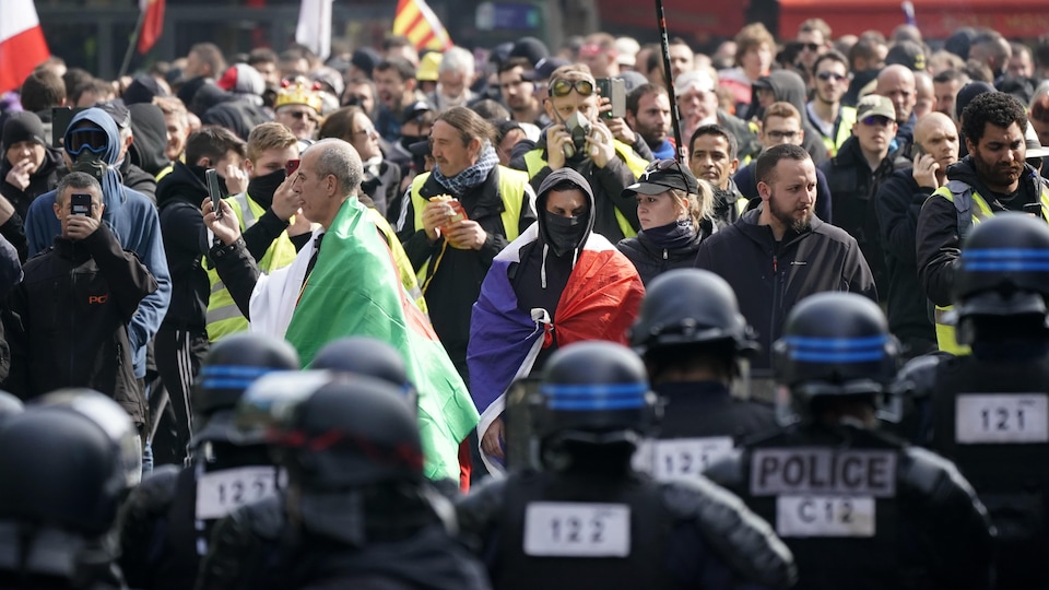 Un cordon de policiers encadre des manifestants.