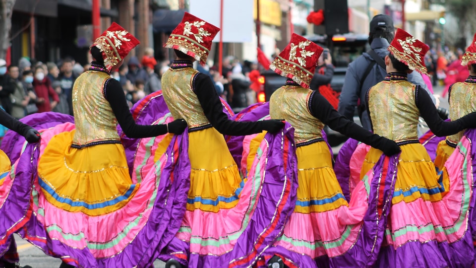 Quatre danseuses en costumes traditionnels défilent dans le quartier chinois à Vancouver.