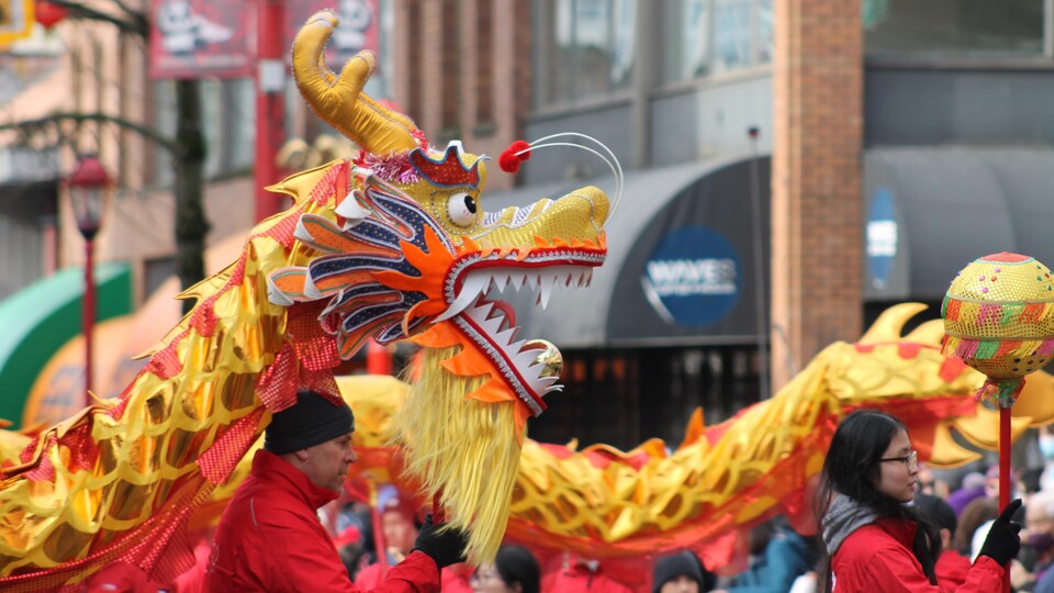 Un dragon est porté par deux personnes lors du défilé du Nouvel An lunaire dans le quartier chinois de Vancouver.