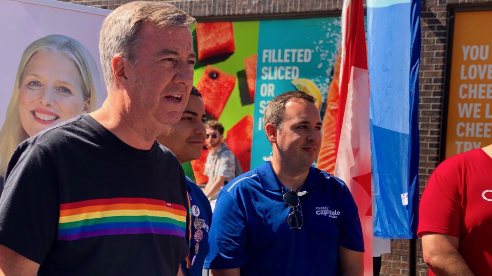 Le maire d'Ottawa Jim Watson dans une conférence de presse avec un chandail aux couleurs de la Fierté gaie.