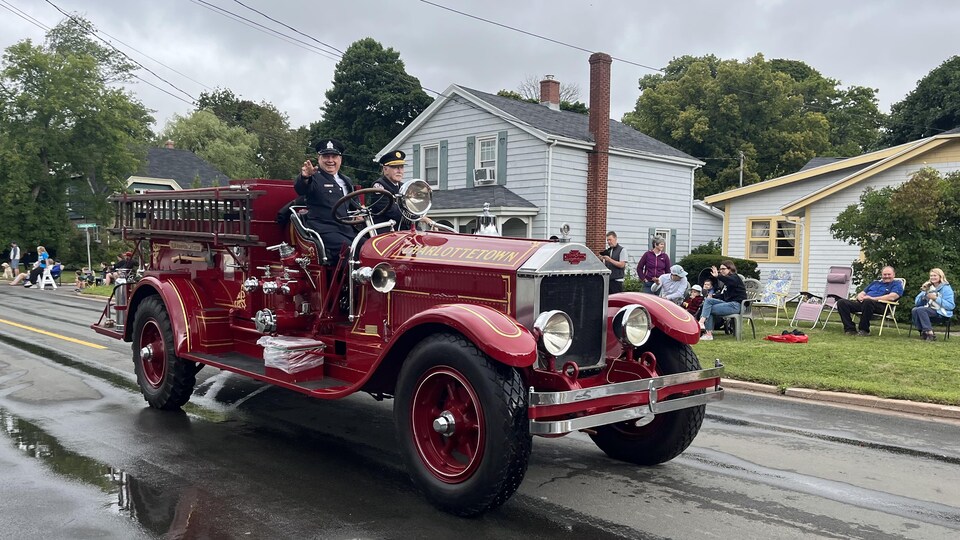 Pompiers sur un vieux véhicule.