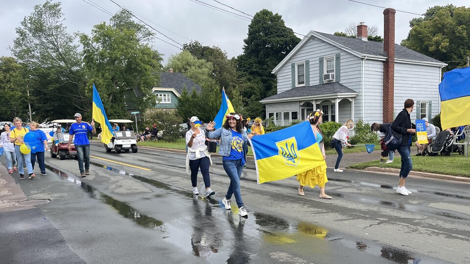 Personnes marchant avec drapeau ukrainien. 