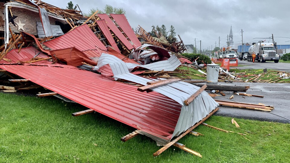 Une toiture arrachée et des débris après le passage d'une tempête.