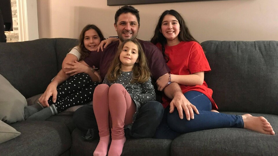 Un homme entouré de trois enfants