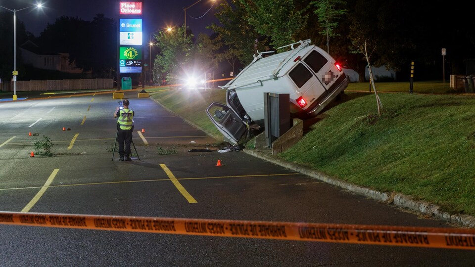 Une camionnette accidentée et un policier qui collige des indices.