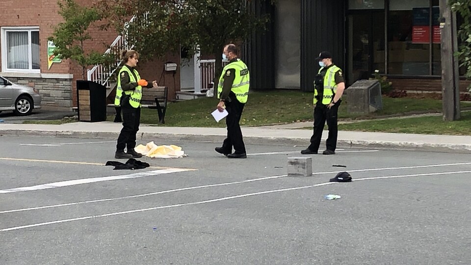 Trois policiers dans la rue.
