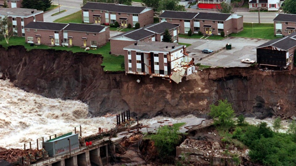 Des immeubles près d'un rivière qui a grugé les terrains qui la borde.