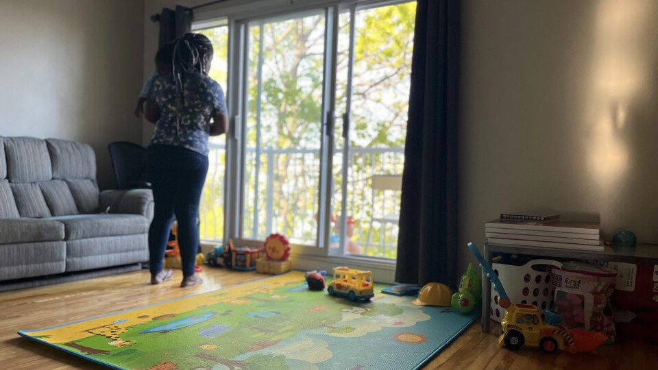 Une femme tient son bébé dans les bras.