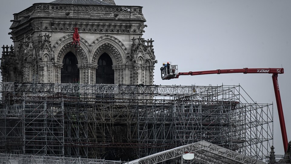Une nacelle est au-dessus d'un gigantesque échafaudage, près des beffrois de la cathédrale.