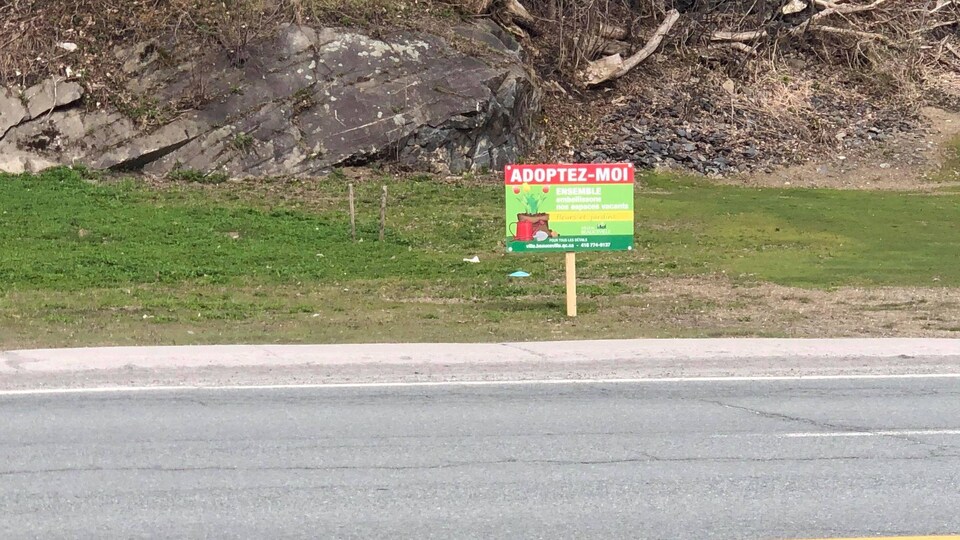 Une affiche plantée dans un terrain.