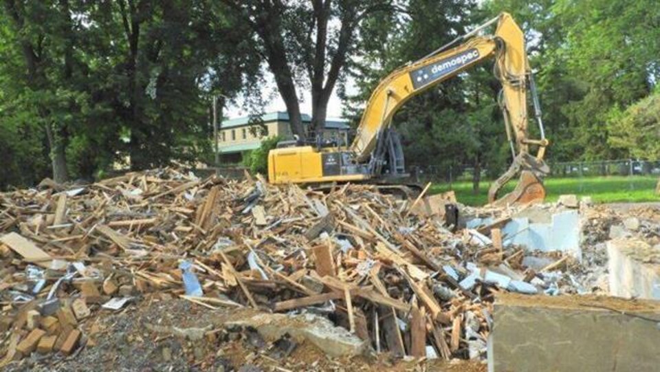 Les décombres de la Maison Pelland à côté d'une grue