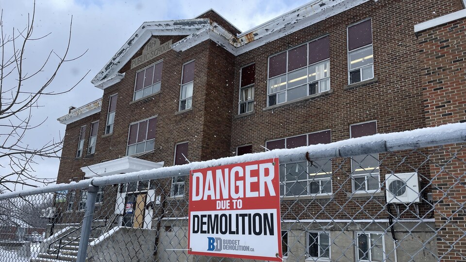 Une affiche indique que des travaux de démolition sont en cours.