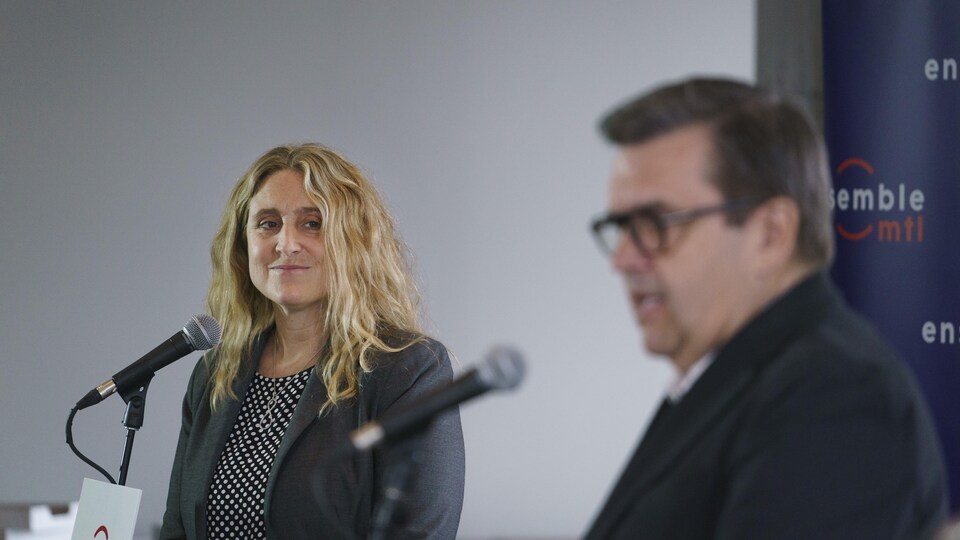 Karine Boivin Roy regarde parler Denis Coderre en souriant.