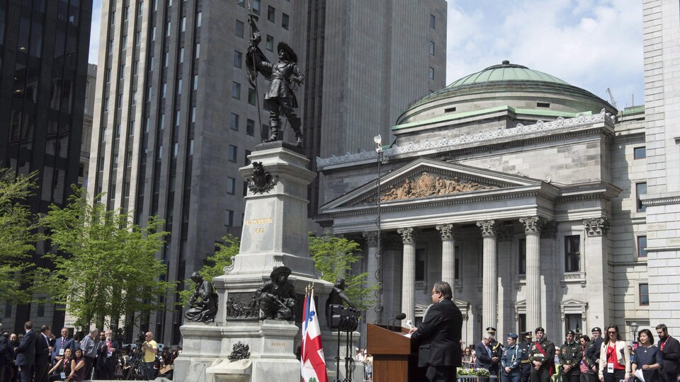 Denis Coderre prononce un discours devant une foule sur la place d'Armes.