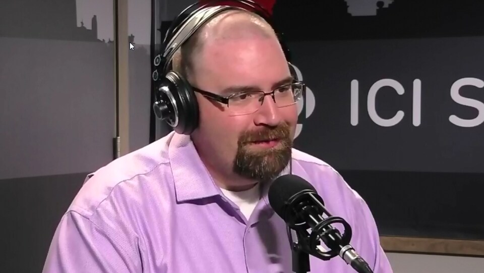 Plan serré de Denis Simard en entrevue à la radio.