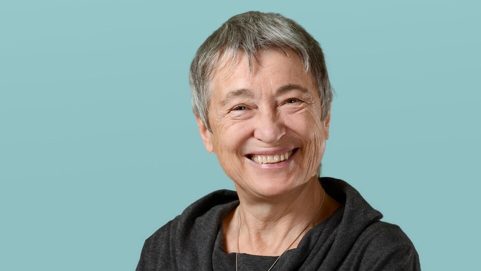 Une femme de 73 ans sourit à la caméra.