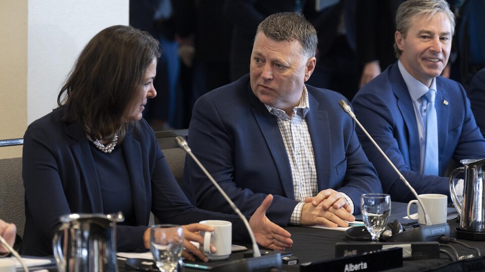 Le premier ministre de l'Île-du-Prince-Édouard, Dennis King (au centre), discute avec la première ministre de l'Alberta, Danielle Smith (à gauche). En compagnie du premier ministre de la Nouvelle-Écosse, Tim Houston (à droite), ils participent à un point de presse à Ottawa le 7 février 2023.