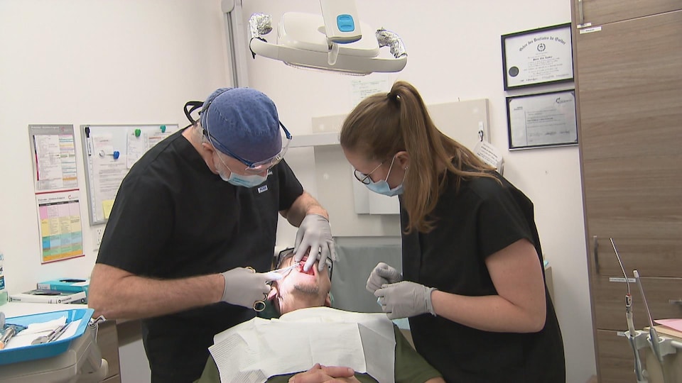 Deux dentistes traitent un patient.