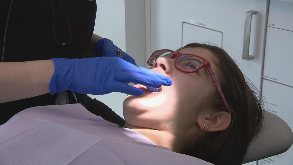 Une patiente sur la chaise du dentiste reçoit des soins.
