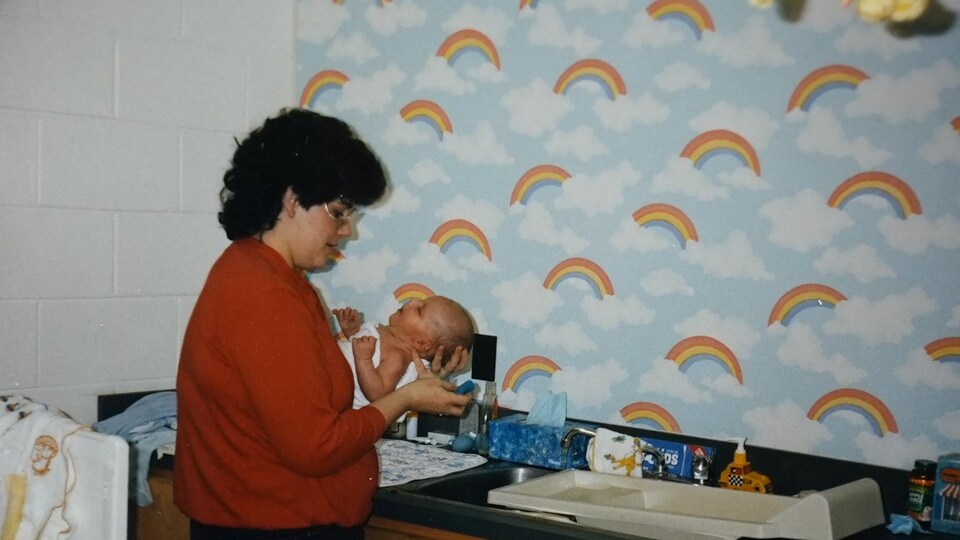 Une femme donne un bain à un bébé.