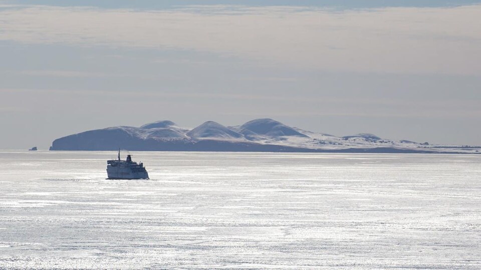 Un bateau au loin avec l'île d'Entrée en arrière-plan.
