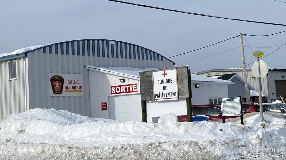La caserne de pompiers, un bâtiment blanc, dans une rue de Mani-utenam avec l'inscription clinique de prélèvement.