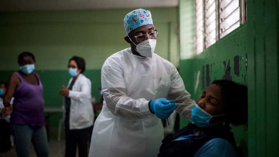 Un travailleur de la santé prélève un échantillon pour un test de dépistage de coronavirus dans une école de Saint-Domingue en République dominicaine.