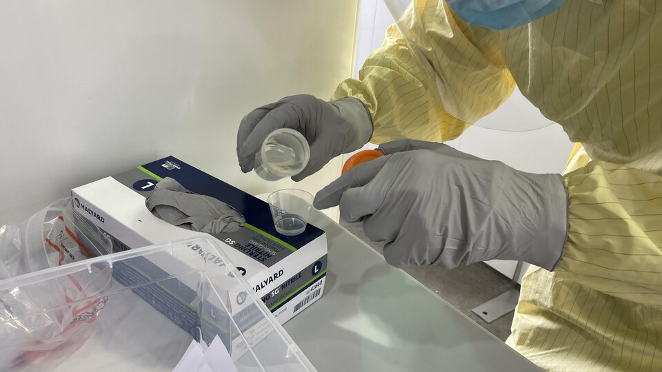 Un travailleur de la santé prépare un test par gargarisme.