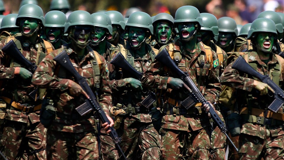 Des soldats défilent avec leurs armes.