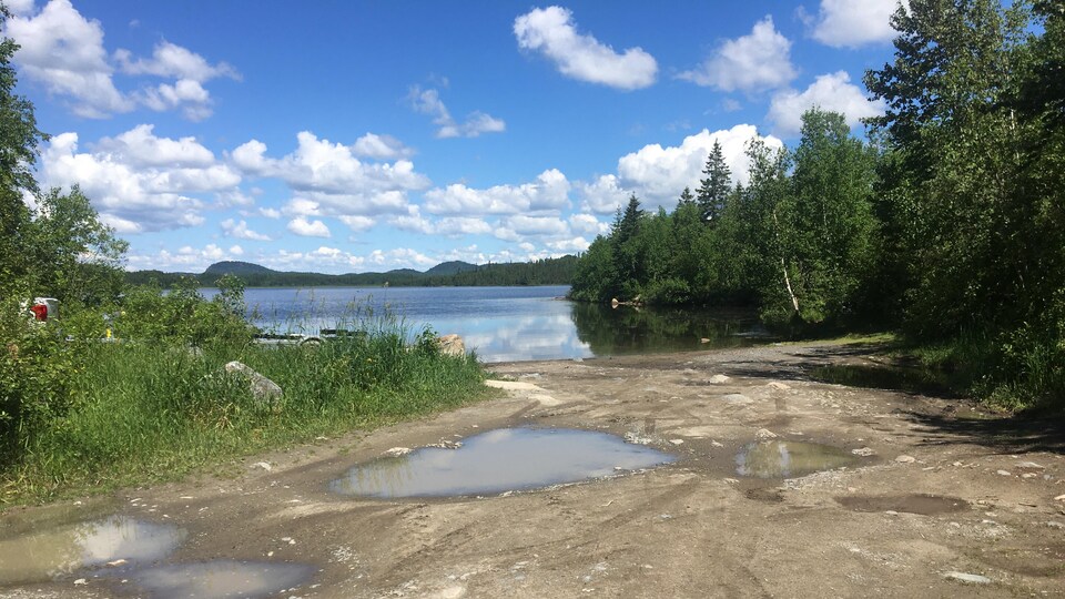 Un chemin au bord de l'eau qui mène à une descente de bateaux.