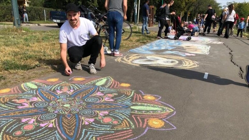 Plusieurs personnes dessinent sur une piste asphaltée.