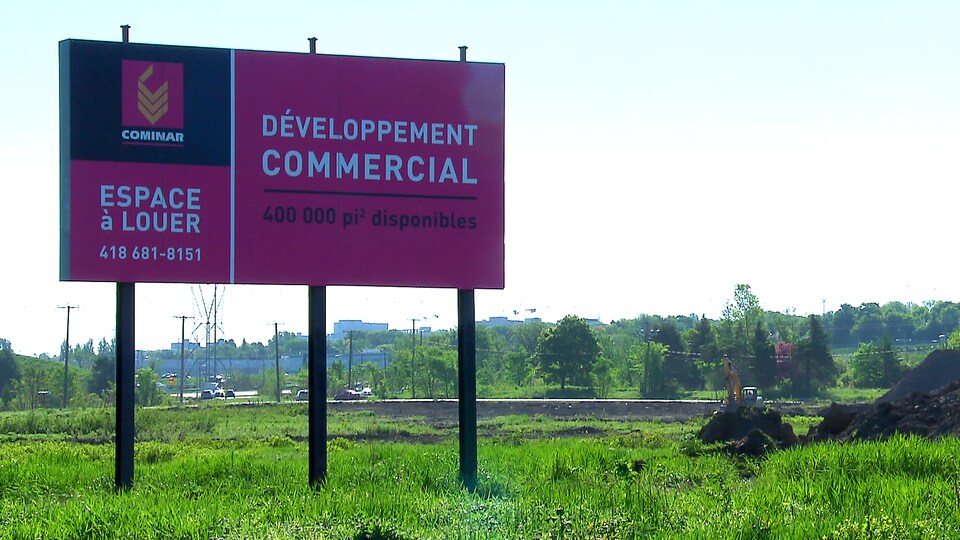 Une affiche annonce un développement commercial à Québec.