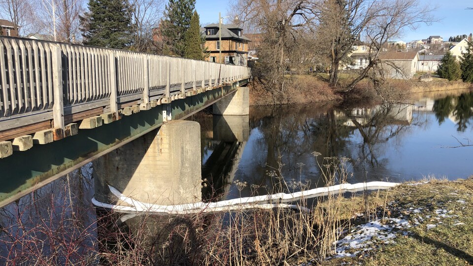Des remblais tubulaires sont toujours en place sur la rivière, près de la passerelle, pour circonscrire et absorber les hydrocarbures.