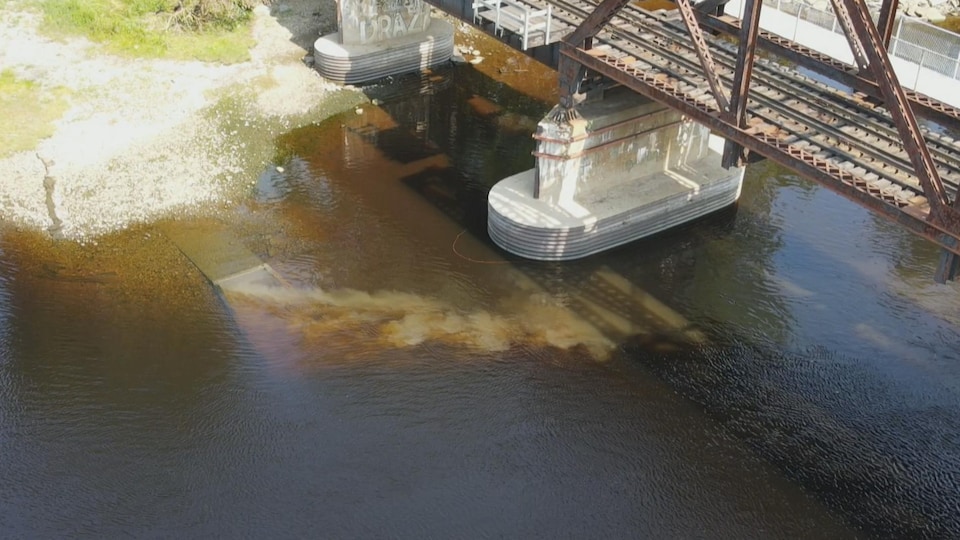 La fuite vue de haut : une colonne brune dans la rivière.