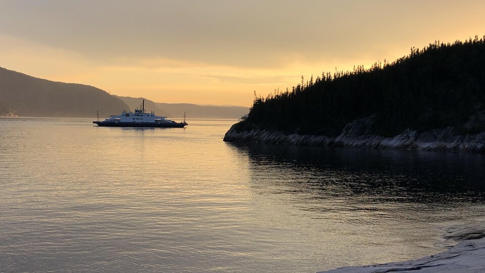 Un traversier sur l'eau, au soleil couchant.