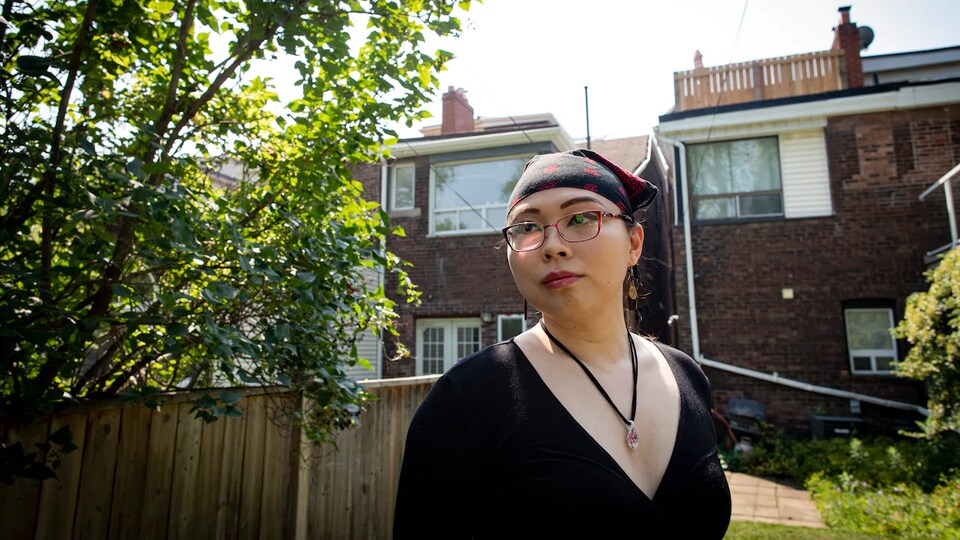 Une femme transgenre dans la cour arrière d'une résidence.