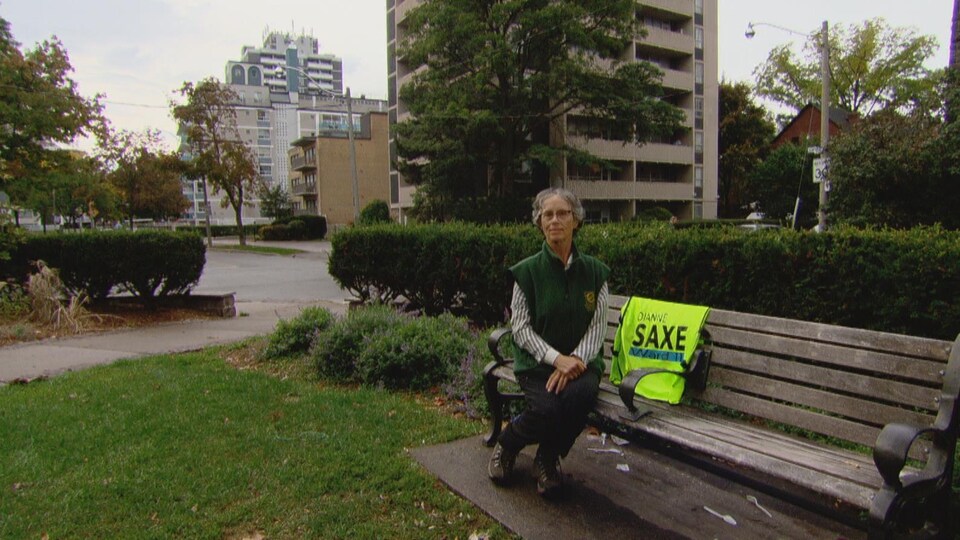 Dianne Saxe, assise sur un banc dans un parc.