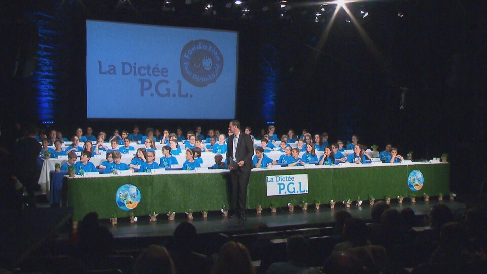 Les participants à la dictée PGL en rangées sur scène.