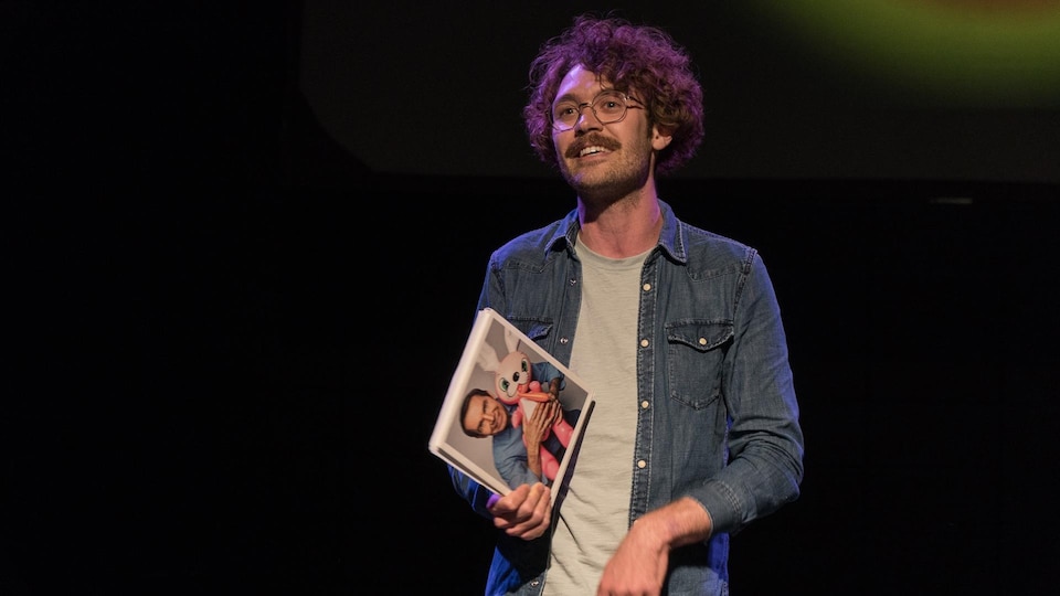 Dillon Orr est éclairé sur une scène de théâtre sombre.