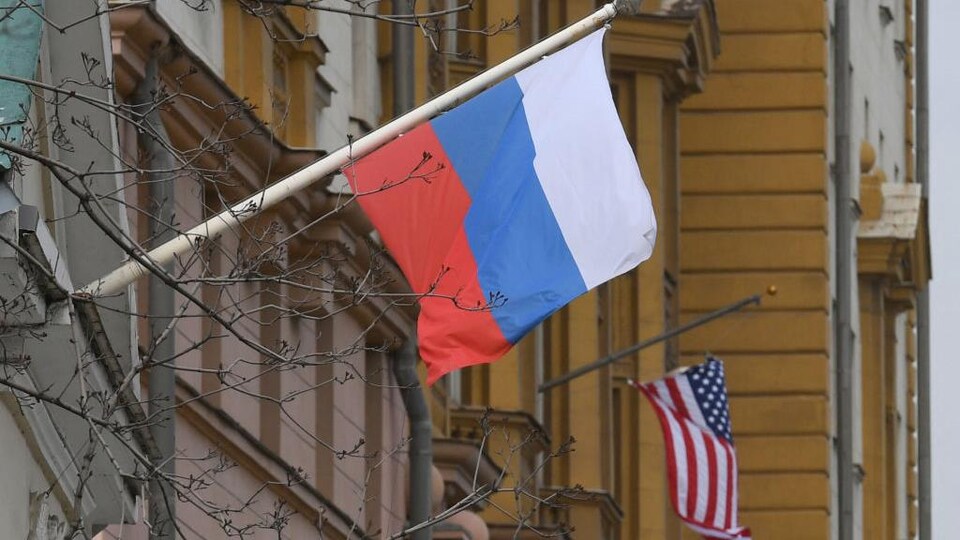 Des drapeaux de la Russie et des États-Unis flottent au vent.