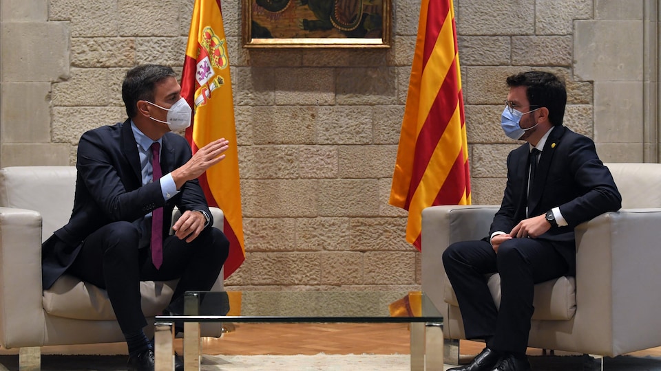 Pedro Sanchez et Pere Aragonès, masqués, discutent, assis dans des fauteuils.