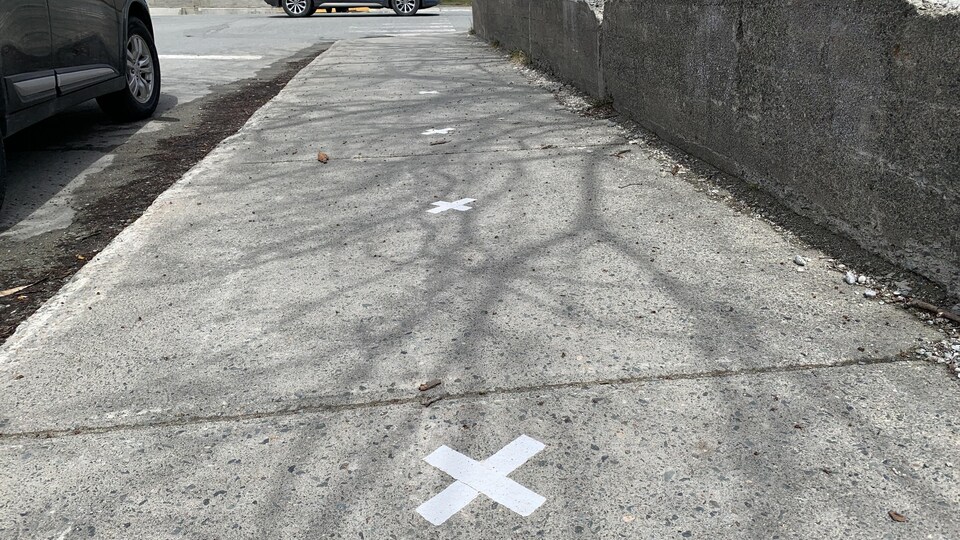Des marqueurs à deux mètres de distance sont collés sur un trottoir de Rouyn-Noranda.