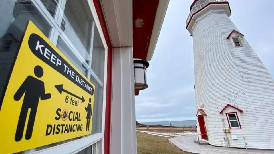 Une affiche qui demande la distanciation sociale près du phare.