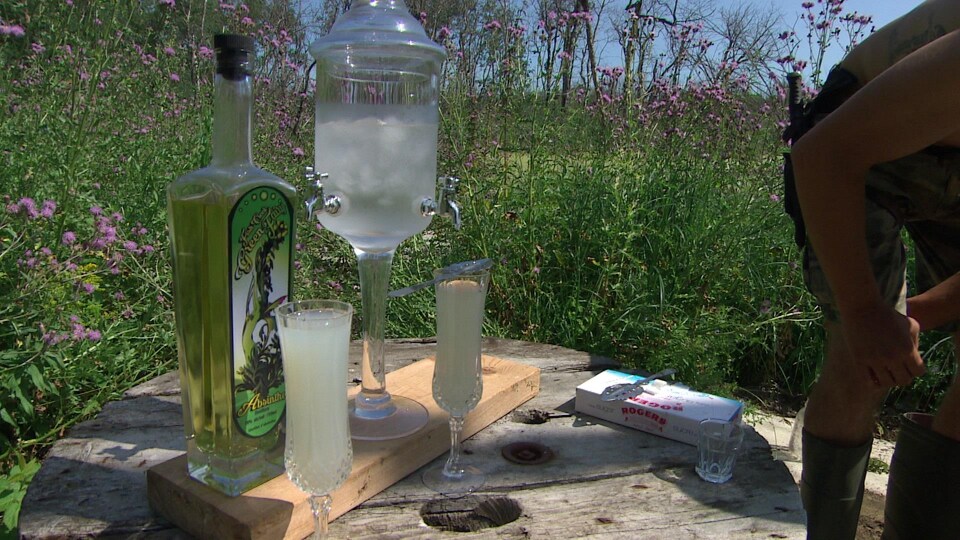 Deux coupes d'absinthe accompagnées d'une fontaine d'eau glacée et d'une bouteille d'absinthe de Great Gido's Homebrew.