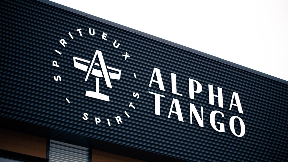 Le logo d'Alpha tango, qui représente un verre de gin surmonté d'un A.