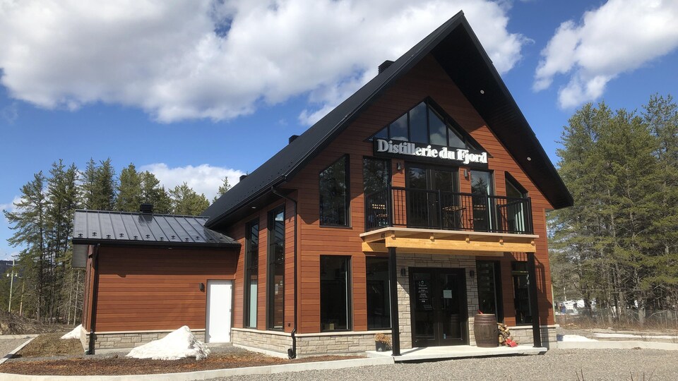 La Distillerie du Fjord se dresse sous un ciel partiellement nuageux.
