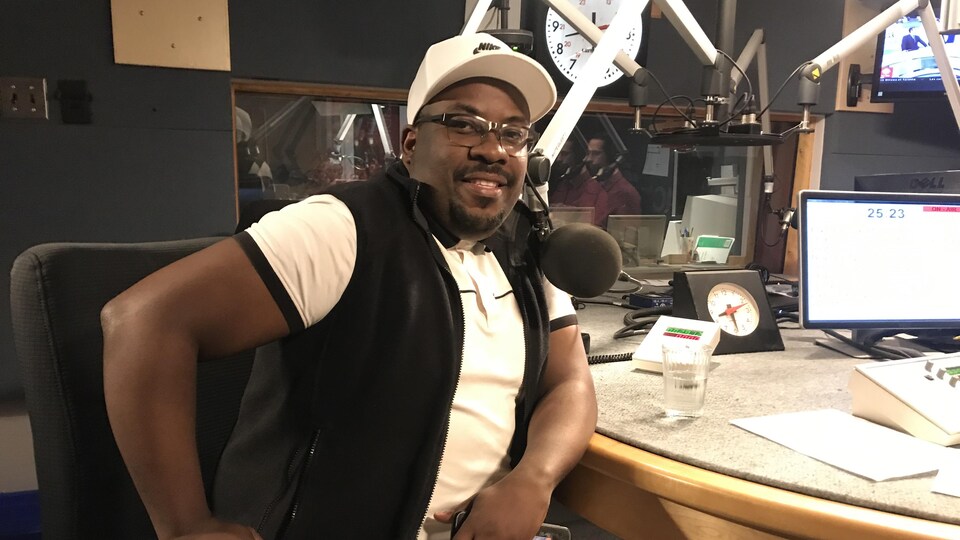 Un homme assis dans un studio de radio.