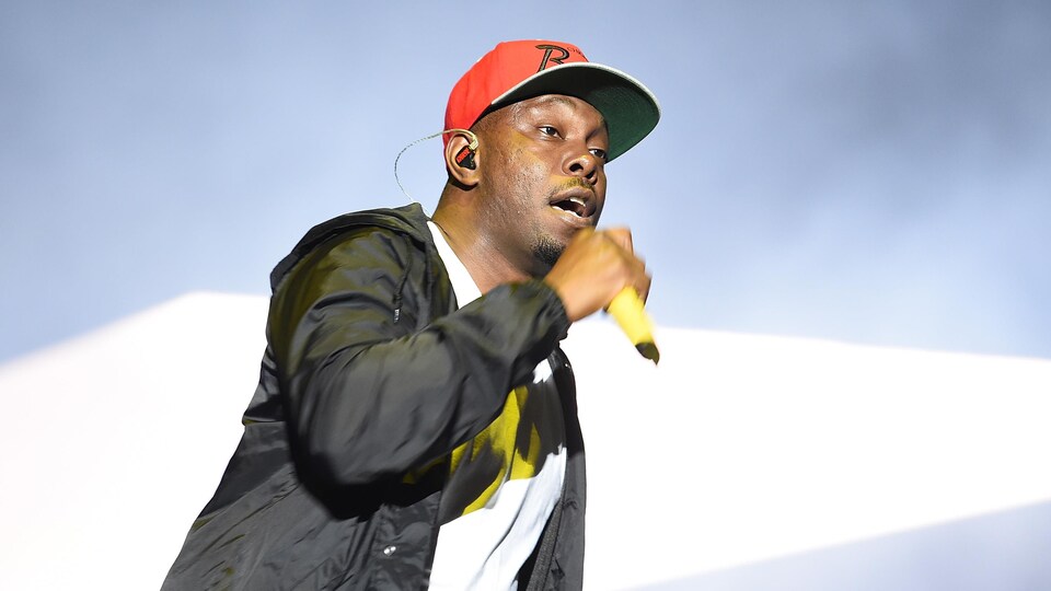 Le rappeur chante sur une scène.